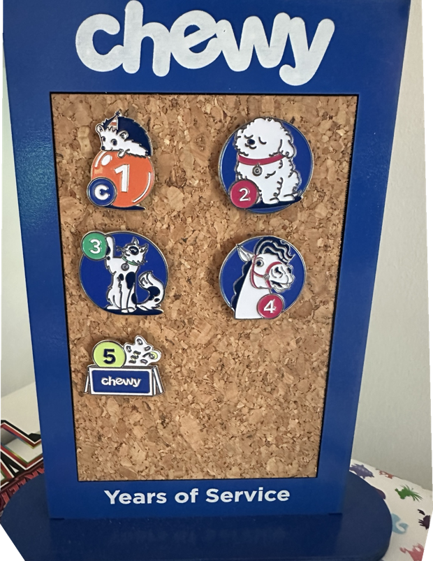 Chewy five years of service board with five badges